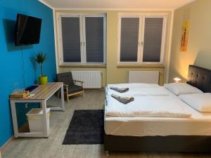 纽伦堡White Pearl Hostel 1的一间卧室配有一张床、一张书桌和一台电视