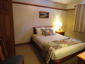 Twin MountainCarlson's Lodge的一间卧室配有一张带台灯和桌子的床