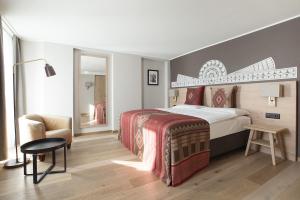 圣莫里茨斯特凡尼酒店的配有一张床和一把椅子的酒店客房