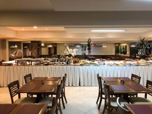 皮拉图巴Hotel Recanto Do Rouxinol的餐厅设有木桌,供应自助餐