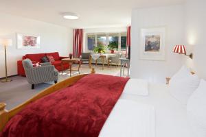 沙伊代格Landhotel Herzberger garni Zimmer & Ferienwohnungen的一间带大床的卧室和一间客厅