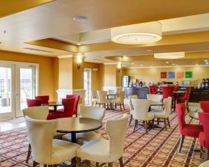 史密斯堡Comfort Inn & Suites Fort Smith I-540的一间带桌椅的餐厅和一间酒吧