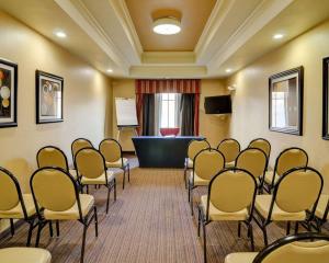 史密斯堡Comfort Inn & Suites Fort Smith I-540的一间房间,配有一束椅子和一个讲台