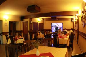 雷京Pensiunea Blanca的一间设有桌椅的餐厅,那里有座位
