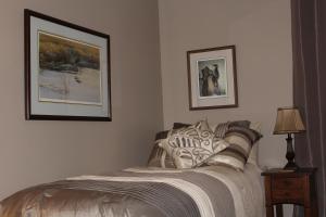 ErinTailwinds B&B的卧室配有一张床,墙上挂有两张照片