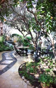 罗什平纳品纳巴尔维旅馆的树下带桌子和长凳的庭院