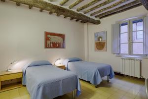 锡耶纳Attilio Camere的一间卧室设有两张床和窗户。