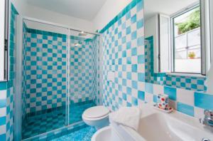 伊斯基亚Villa Vincenzo Di Meglio的蓝色瓷砖浴室设有卫生间和水槽