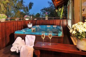 罗什平纳品纳巴尔维旅馆的甲板上的热水浴池,备有两杯葡萄酒
