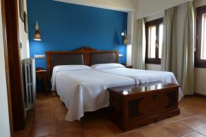 洛阿雷洛阿雷霍斯佩德里亚酒店的一间卧室设有一张蓝色墙壁的大床