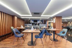 特拉布宗特拉布宗帕克德德曼酒店的餐厅设有木墙和桌子以及蓝色的椅子