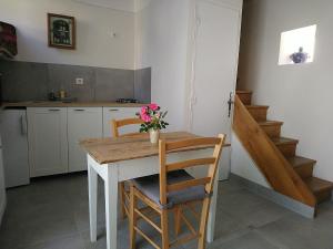 芒德La Soubeyranne的厨房配有桌子和两把带鲜花的椅子