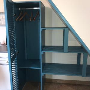 Bois dʼOliveTi Kaz Ravinala的楼梯下面的蓝色书架