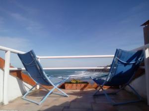蒙达卡Mundaka Vista Mar L-BI-52的两把椅子坐在一个俯瞰着大海的阳台