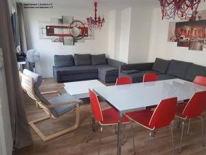 万塞讷万塞讷公寓的客厅配有白色桌子和红色椅子
