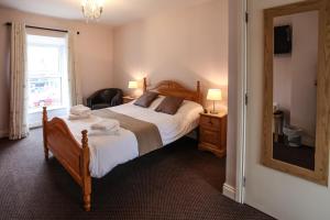 莫维尔温馨小屋式酒店的一间卧室设有一张床、一个窗口和一面镜子