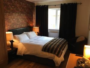 亚达尔Abbeyvilla Guesthouse Room Only的一间卧室设有一张床和砖墙