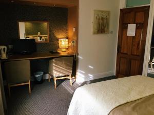 亚达尔Abbeyvilla Guesthouse Room Only的酒店客房配有一张床和一张带电脑的书桌