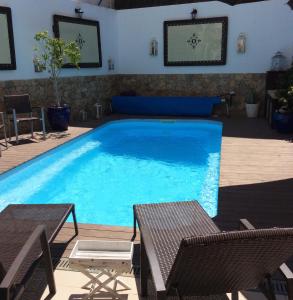 法鲁Opus One Luxury Guest House & Wine的一个带两把椅子和一张桌子的大型游泳池