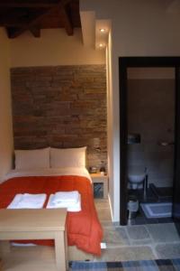 卡兰巴卡Thalia Rooms的一间卧室配有一张带橙色毯子的床