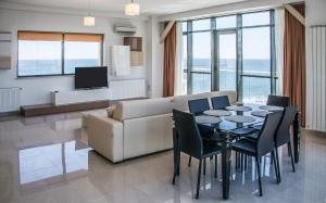 马马亚海滨住宅公寓酒店的客厅配有桌子和沙发