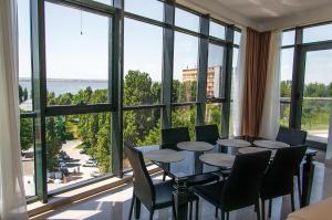 马马亚海滨住宅公寓酒店的一间带桌椅和大窗户的用餐室