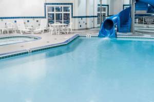 High River华美达高地河流酒店的一座大楼内带水滑梯的游泳池