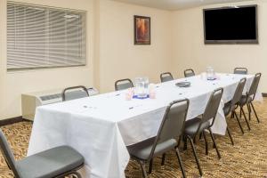 安卡斯维尔Microtel Inn & Suites by Wyndham Uncasville Casino Area的一间会议室,配有一张白色的大桌子和椅子