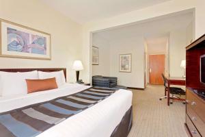 德斯坦德斯坦温德姆集团温盖特酒店的酒店客房设有一张大床和一张书桌。