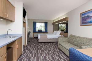 安克雷奇Baymont Inn & Suites by Wyndham Anchorage Airport的酒店客房,配有床和沙发
