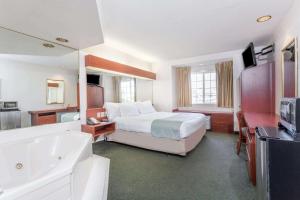 玛丽安娜Microtel Inn & Suites Marianna的酒店客房配有一张床和浴缸。