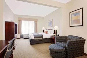 德斯坦德斯坦温德姆集团温盖特酒店的配有一张床和一把椅子的酒店客房
