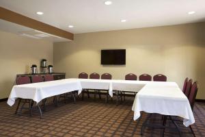 奥德萨Microtel Inn & Suites by Wyndham Odessa TX的一间会议室,配有白色的桌椅和电视