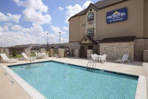 奥德萨Microtel Inn & Suites by Wyndham Odessa TX的酒店前的游泳池