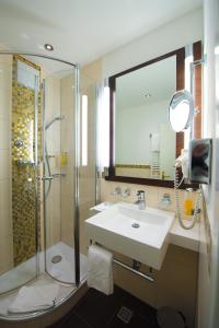 波恩凯瑟尔霍夫贝斯特韦斯特酒店的一间带水槽、淋浴和镜子的浴室