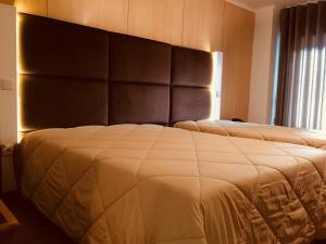 阿吉亚尔小镇欧罗巴酒店的一间卧室配有一张大床和大床头板