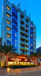 迪拜Pearl Marina Hotel Apartments的一座高大的蓝色建筑,前面有标志