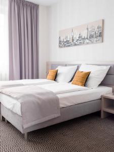 博莱斯瓦维茨Hotel Chrobrego9的一间卧室配有一张带白色和黄色枕头的大床