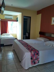 克拉图Hotel Encosta da Serra CRATO CE的酒店客房设有两张床和窗户。