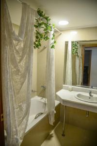 阿尔塔阿尔塔宫殿酒店的带浴缸、水槽和淋浴帘的浴室