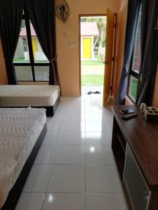 马六甲Mutiara Chalet的一间卧室配有两张床、一张桌子和一扇门