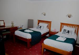 威萧赫斯希尔旅馆的客房设有两张床、一张桌子和一面镜子。