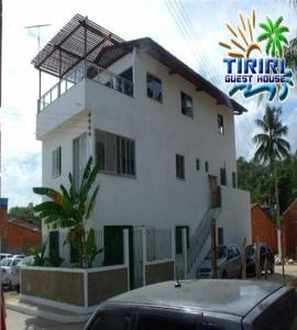 Barra do CamaragibePousada Tiriri Guesthouse的一座大型白色房子,前面有一辆汽车
