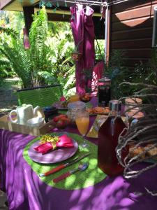 La RivièreLe Chalet dAZAE的一张带食物和一瓶果汁的野餐桌