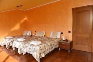 罗马诺迪隆巴尔迪亚Welcome Garden的一间卧室设有两张床,铺有木地板