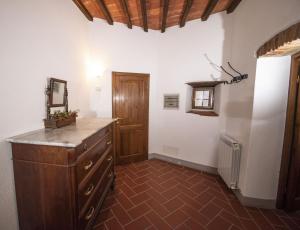 拉达-因基安蒂Casa Selvolini - VOLPAIA的一间设有梳妆台和木门的房间