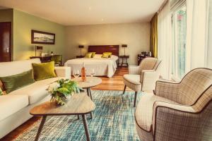 施德波斯Hostellerie Schuddebeurs的酒店客房设有床、沙发和桌子。