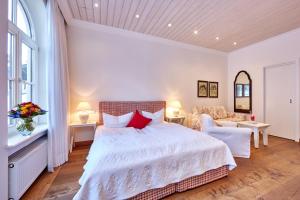 法尔先特福赫霍夫嘉妮酒店的卧室配有一张白色的大床和一张沙发。