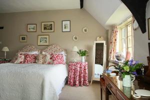 埃克塞特Brook Farmhouse的卧室配有带红色枕头的白色床