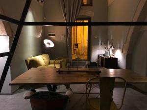 圣维托诺曼La Stratodda Dimora Loft Mare Bandiera Blu 2023的一间带木桌和椅子的用餐室